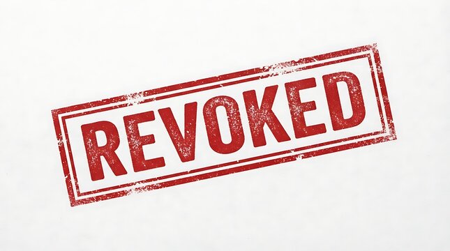 Red grunge rubber stamp impression with the word revoked on white textured paper
