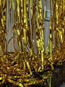 Close up of shiny gold metallic foil fringe tinsel curtain decoration for a party background