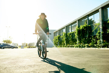Naklejka premium Man, bicycle and sport for outdoor activity, hobby or challenge in parking lot. Bike, person and urban street for cycling, BMX training and skills for competition with balance and stunt exercise