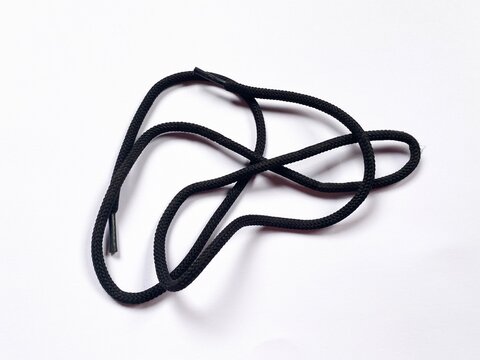 Black round shoelaces untangled randomly isolated on clean white background