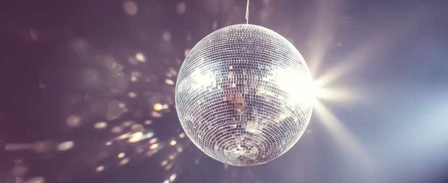 Disco ball hanging, reflecting light and creating starburst patterns for a vibrant party atmosphere