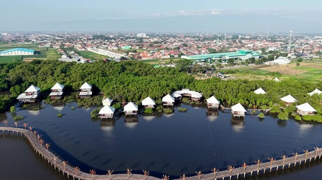 Wooden walkways connect white tented structures beside calm waters at Probolinggo