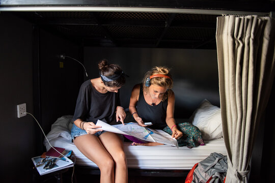 Two young women studying together in a cozy bunk bed workspace