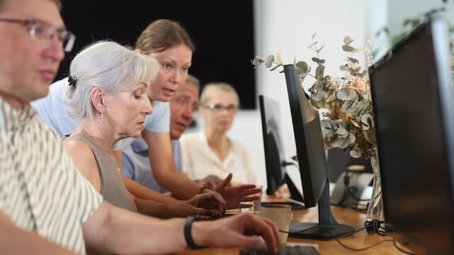 Group of elderly people learn to use computer at master class 