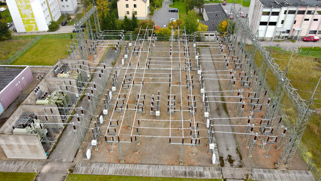 Electrical substation provides power distribution, featuring multiple transformers, high voltage cables, and intricate grid infrastructure for urban energy supply