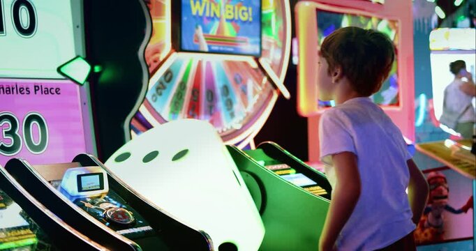Young Boy Playing Arcade Game Surrounded by Colorful Neon Lights
