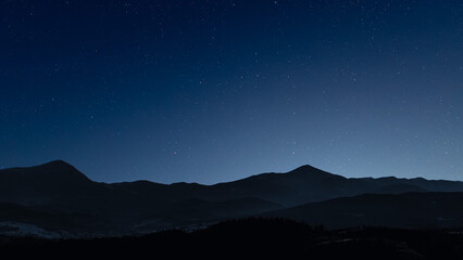 Fototapeta premium Glowing Christmas star above a peaceful mountain landscape
