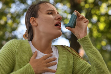 Asthma attack and respiratory health, young woman using a medical inhaler for breathing difficulty...
