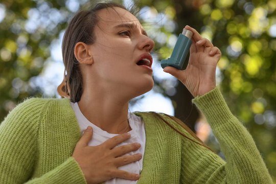 Asthma attack and respiratory health, young woman using a medical inhaler for breathing difficulty and allergy symptoms in a park