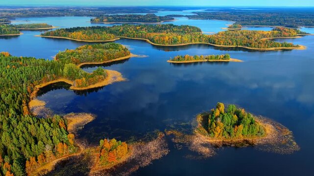 Aerial view of colorful autumn foliage over tranquil lakes and forested islands