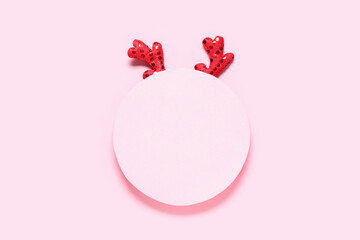 Blank paper with reindeer horns on pink background © Pixel-Shot