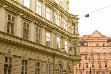 Ornate late 19th century apartment facades green and warm beige color, tall sash windows © Alena