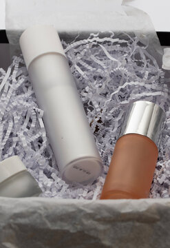 Modern beauty collection showcasing an assortment of frosted glass skincare containers, a minimalist white boo for Christmas celebration