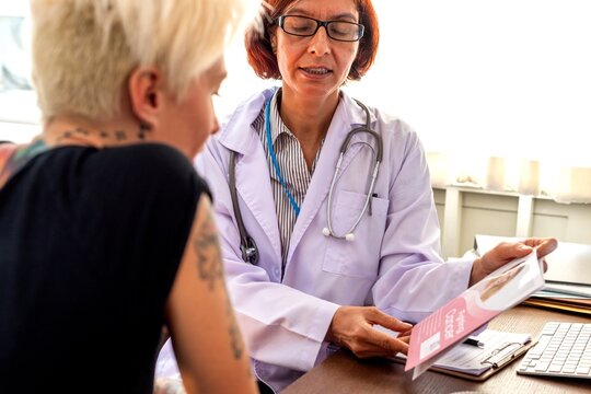 Doctor discussing a pamphlet with a patient in a medical office.