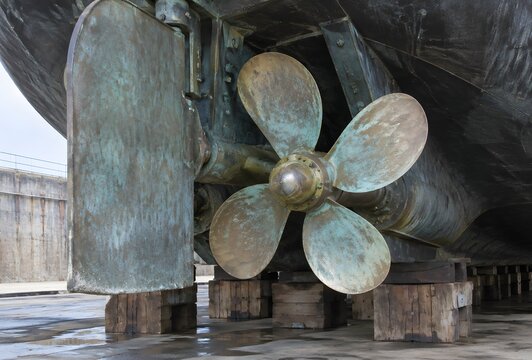 Bronze ship propeller and rudder assembly seen in drydock