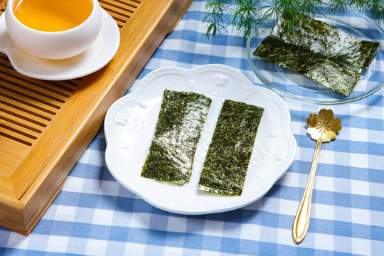 Roasted Seaweed Sheets On Clear Glass Plate With Tea Set