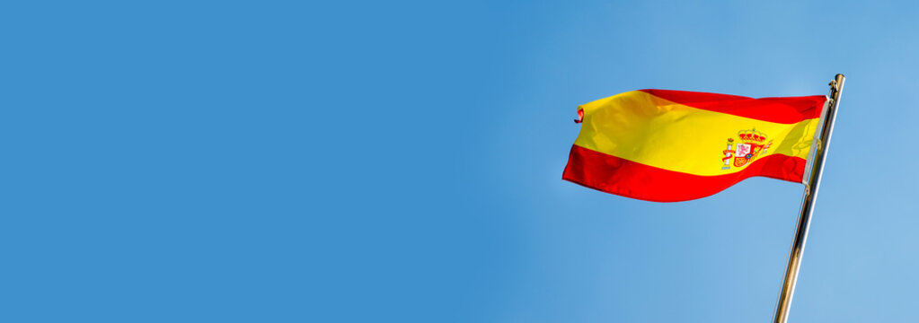  Spanish flag flying on a metal flag pole
