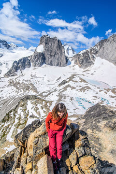 Smiling woman on a rocky summit overlooking a glacier