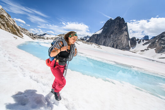 Female mountaineer hiking through a snowy mountain landscape