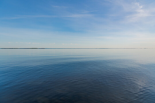 Calm blue water ripples under a clear sky