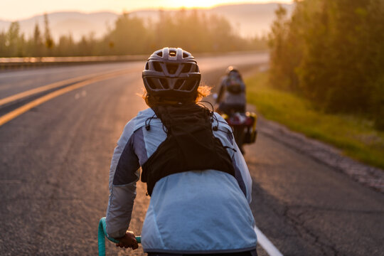 Two cyclists on a scenic road at golden hour