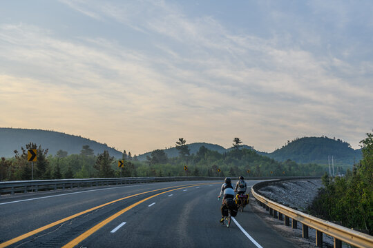 Two people on a bike packing adventure on a rural highway