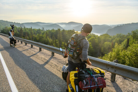 Two cyclists enjoy the view on a scenic mountain road trip
