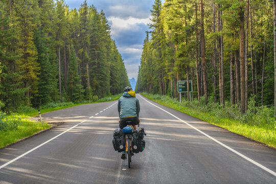 Bike packer cycling down a long empty road