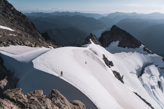 Lone hiker traverses a vast snowy mountain