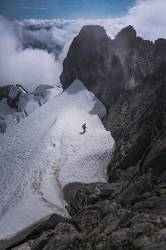 Solo Climber Traversing Narrow Snowy Ridge in Tantalus Range