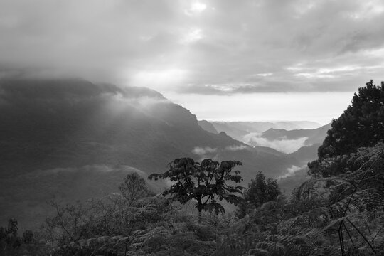 Sun rays break through clouds over mountain valley