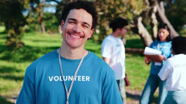 Volunteer, face or happy man in park for outdoor charity, contribution or community service together. Portrait, male person or NGO with smile for social responsibility or team outreach in nature