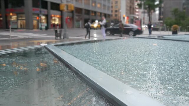 Manhattan Midtown East 53 street, New York City, United States. Yellow taxi car, Lexington avenue road traffic. Rainy day weather, drops on pavement, wet sidewalk in central business district. morning