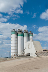 Industrial concrete plant with silos under blue sky © MexChriss