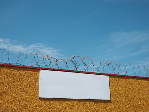 Blank Sign On Barbed Wire Wall