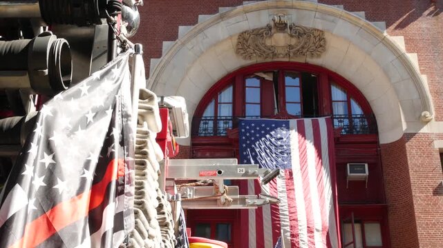 Red thin line black american flag on firefighter truck. Hose of firetruck and fire fighters symbol in New York, United States. 911 remembrance, fire department engine vehicle. September 11 Patriot Day