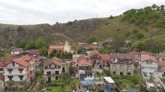 Aerial view pulling back from the traditional village of Lin, Albania. The quaint town with red tiled roofs sits on the Lake Ohrid shore