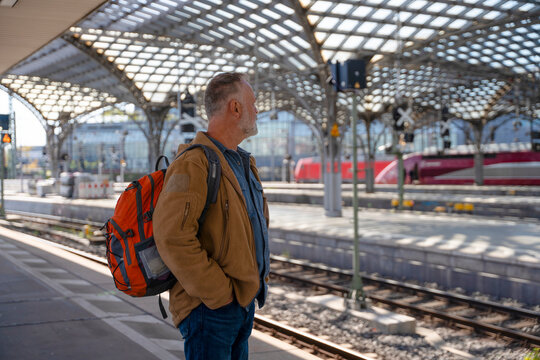 Man waits at a train station for his journey