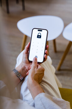 Smartphone with fingerprint lock authentication held by hand indoors