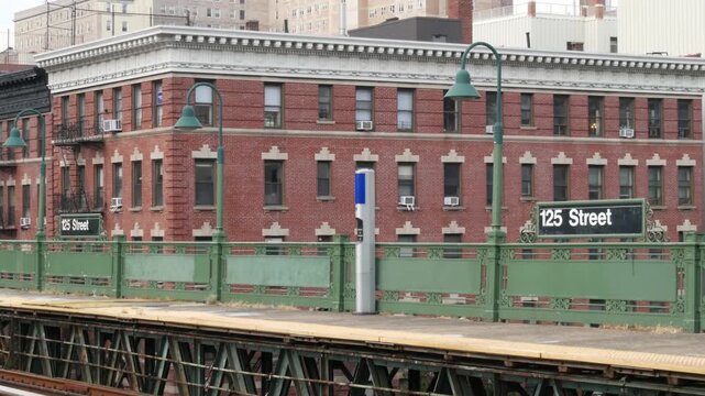 New York City Upper Manhattan subway outdoor station platform, 125 street sign, elevated metro in Harlem, United States railway. Residential district public metropolitan transport. Apartment houses.