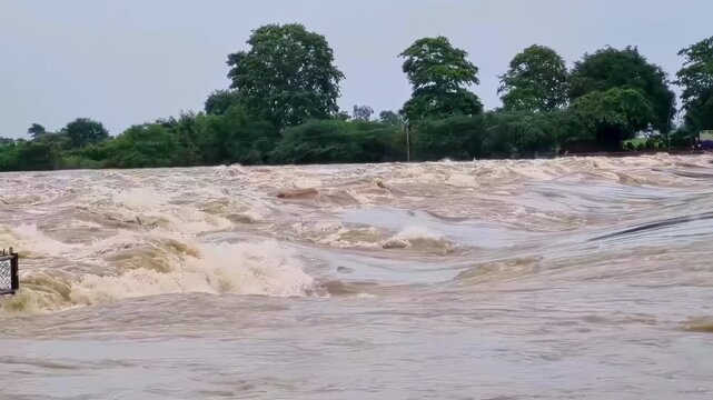 Close-up of a river overflowing and strong currents as a result of flooding in India.
