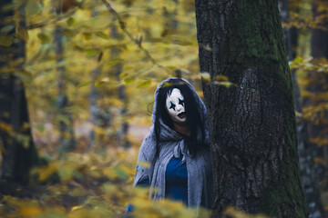 Fototapeta premium Horror background of a ghostly figure in enchanted a forest on a moody autumn day.