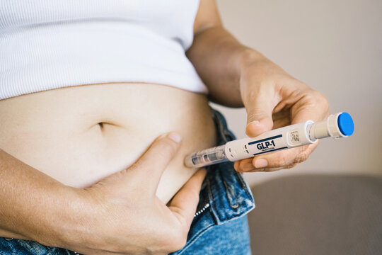 Woman using GLP-1 injection pen as part of weight management treatment