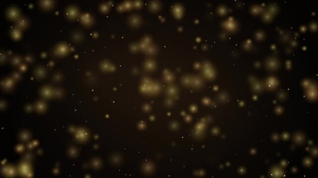 Golden bokeh particles falling slowly against a dark brown background in slow motion.