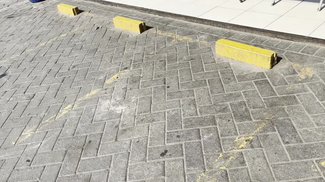Orange Concrete Wheel Stops on Paving Block Parking Lot