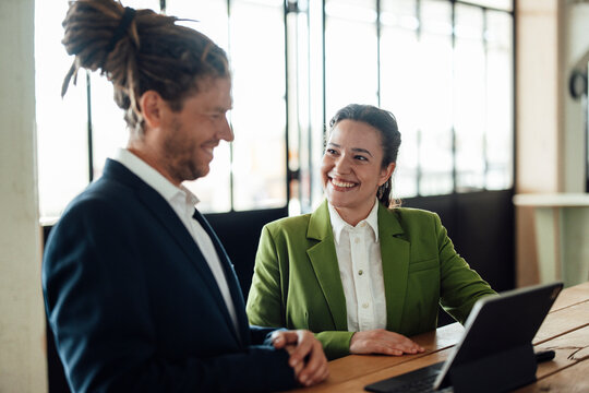 Smiling businessman and businesswoman discuss design at the office