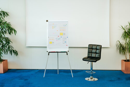 Empty modern conference room with flip chart and chair