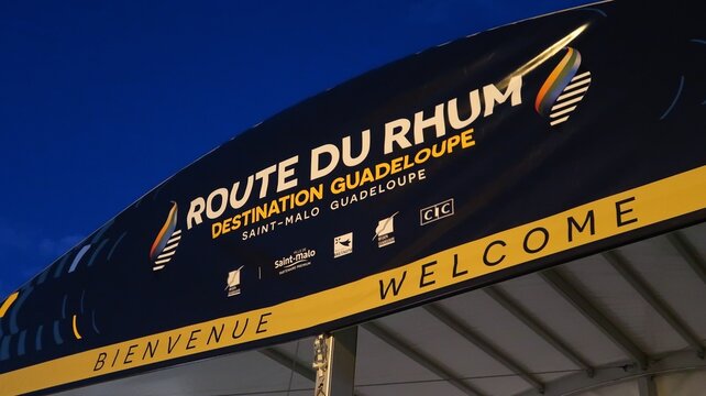"Route du Rhum &ndash; Destination Guadeloupe &ndash; Saint-Malo Guadeloupe" (c&eacute;l&egrave;bre course transatlantique &agrave; la voile) inscrit sur une banderole publicitaire, avec son logo &ndash; novembre 2022 (France)