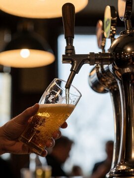 Pouring draft beer from tap into glass