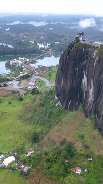 Guatap&eacute; with Piedra del Pe&ntilde;ol Rising Above the Reservoir in Antioquia, Colombia. Establishing Shot. Aerial View. Vertical Video.